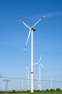 Low angle view of windmill against clear blue sky