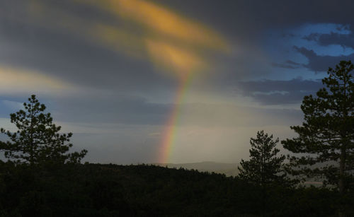 Low angle view of rainbow against sky at sunset