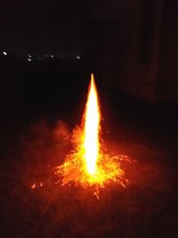 Close-up of illuminated fire against sky at night