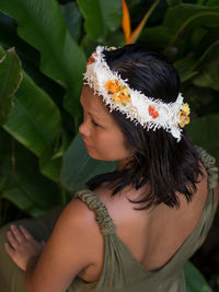 High angle view of woman wearing flowers by plants