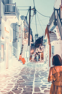 Rear view of people standing on street market in city