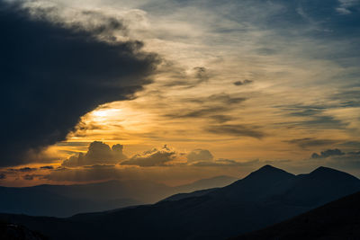Scenic view of silhouette mountains against sky during sunset