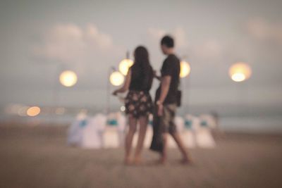 Defocused image of people at beach during sunset