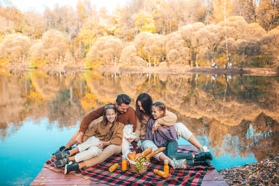 Family sitting by lake