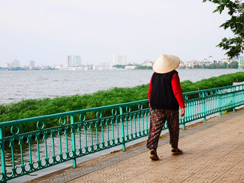 Rear view of vietnamese woman walking by west lake in hanoi