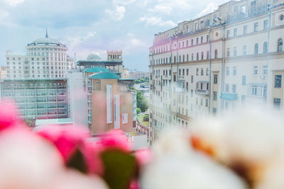 Buildings in city against cloudy sky