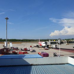 Airplane on airport runway against sky