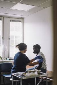 Teenage male patient taking vaccination on arm at hospital