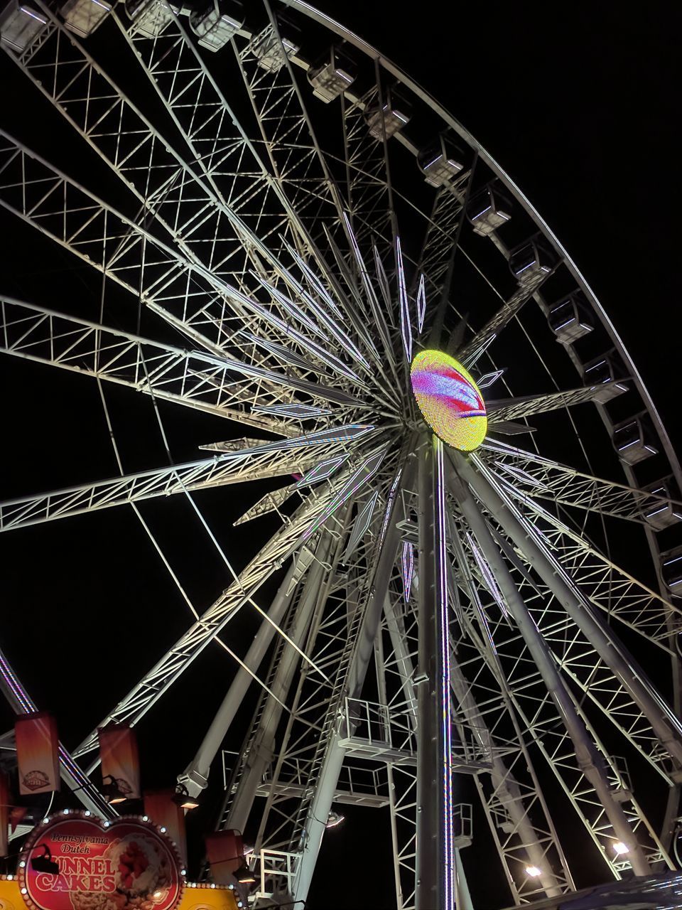 LOW ANGLE VIEW OF ILLUMINATED FERRIS WHEEL AT NIGHT