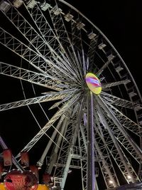 Low angle view of illuminated ferris wheel against sky at night