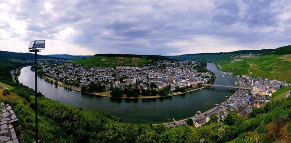 Scenic view of river amidst buildings against sky