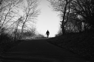 Rear view of man walking on road