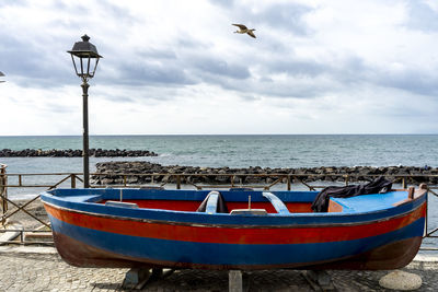 Boat moored at beach against sky
