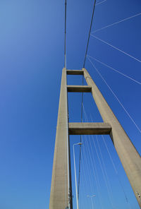 Low angle view of suspension bridge against clear blue sky