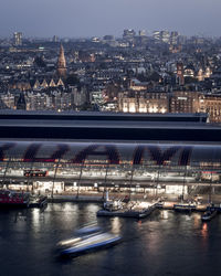 Illuminated bridge over river in city