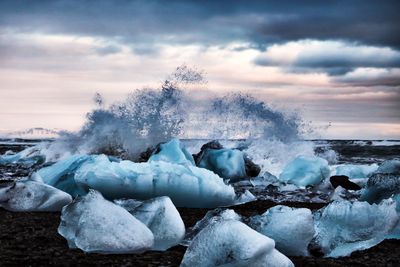 Frozen sea against sky during winter