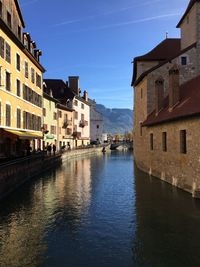 Canal amidst buildings in town against sky