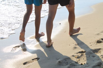 Low section of people standing on beach