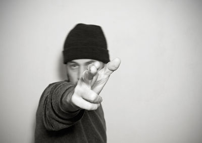 Portrait of man gesturing against wall