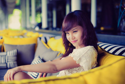 Portrait of young woman sitting at home