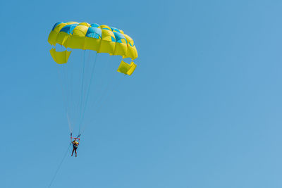 Low angle view of kite flying against clear blue sky