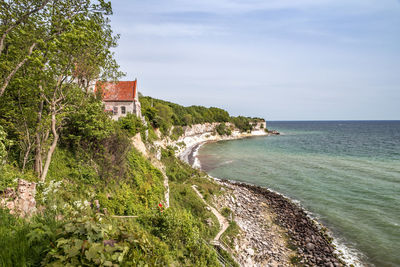 Scenic view of sea by buildings against sky