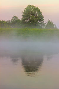 Scenic view of lake against sky at sunset