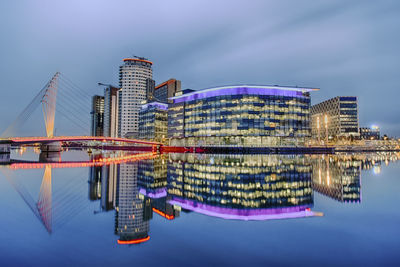 Illuminated modern buildings in city at waterfront