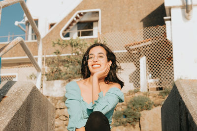 Portrait of a smiling young woman against building