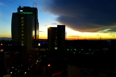 Low angle view of illuminated city at sunset