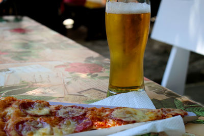 Beer and pizza served on table