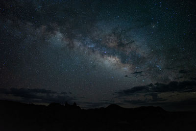 Low angle view of silhouette landscape against star field at night