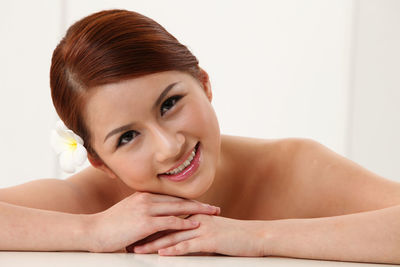 Close-up of beautiful young woman wearing flower at home