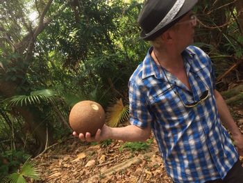 Man holding fruit in forest