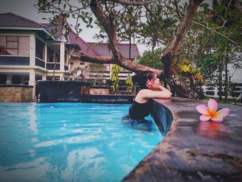 Woman in swimming pool against trees