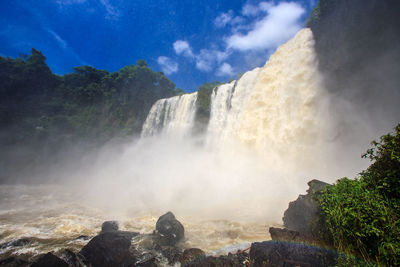 Scenic view of waterfall against sky