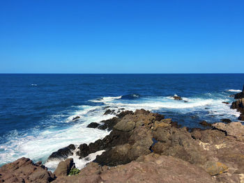 Scenic view of sea against clear blue sky