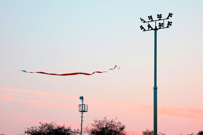 Low angle view of street lights against sky during sunset