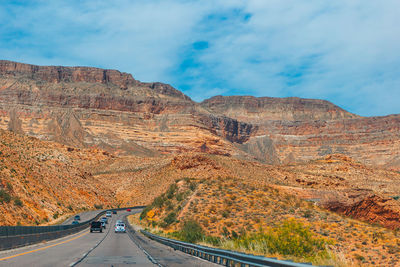 Road amidst rocky mountains against sky