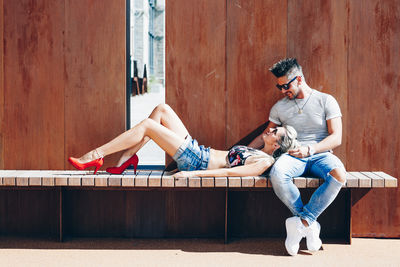 Young couple sitting on wall