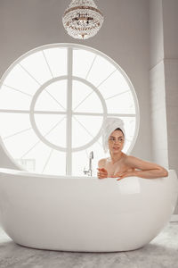 Portrait of young woman sitting in bathroom