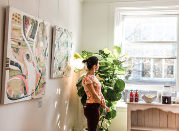 Woman standing by window at home