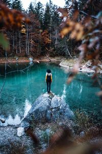 Man standing by lake in forest