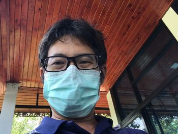 Portrait of man wearing mask against brick wall