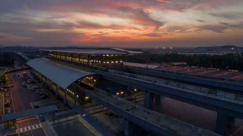 Cars on road in city against sky during sunset