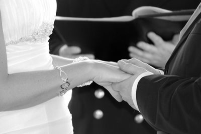 Midsection of bride and bridegroom taking wedding vows