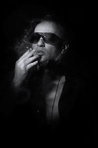 Reflection of man smoking on black background