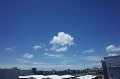 Buildings in city against blue sky