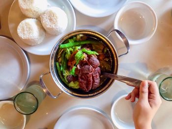 Directly above shot of cropped person food served on table