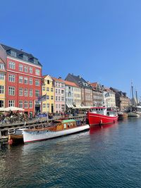 Boats in sea against clear blue sky